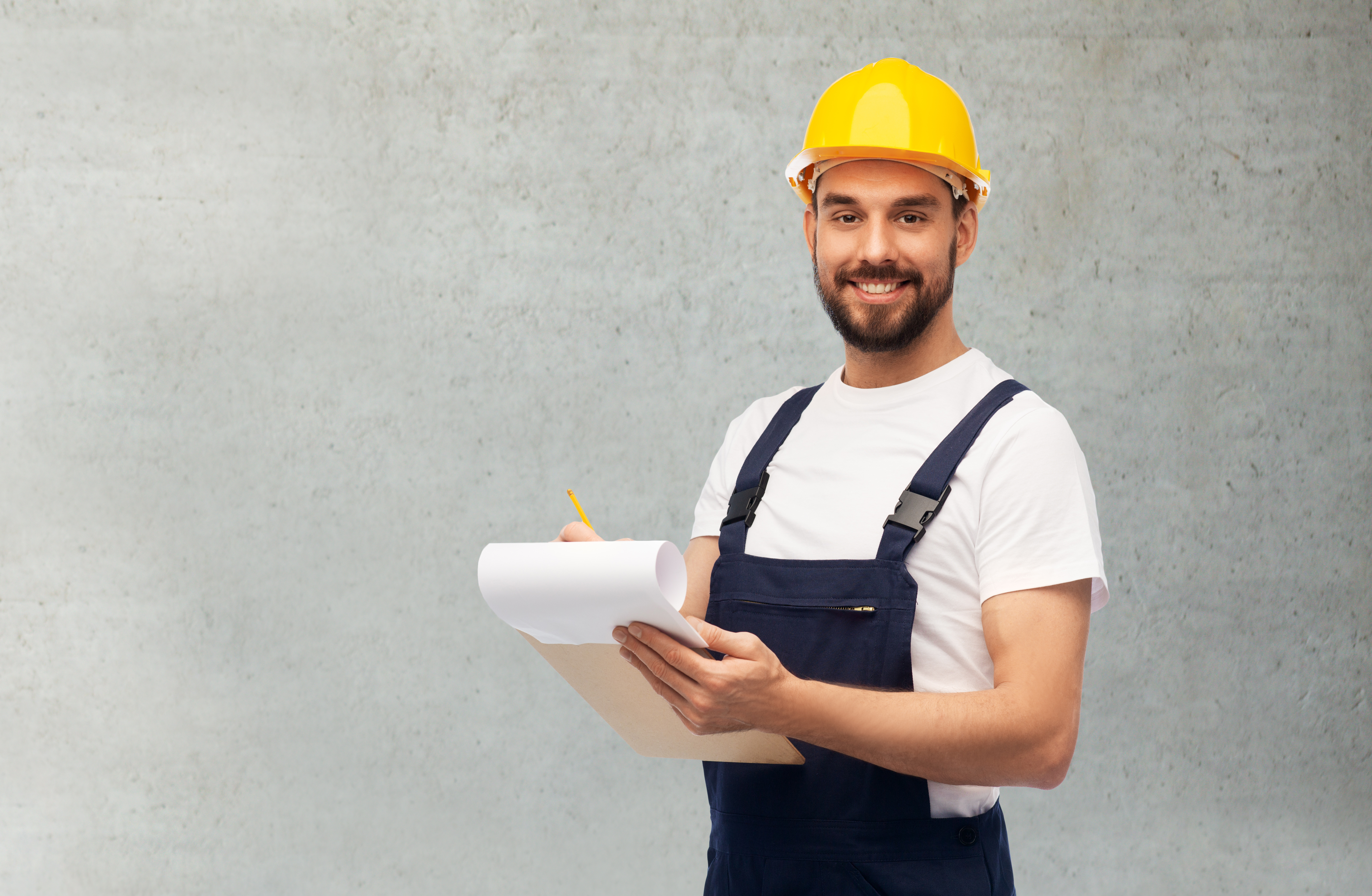 male worker or builder in helmet with clipboard Plumbing contractor reviewing job site checklist