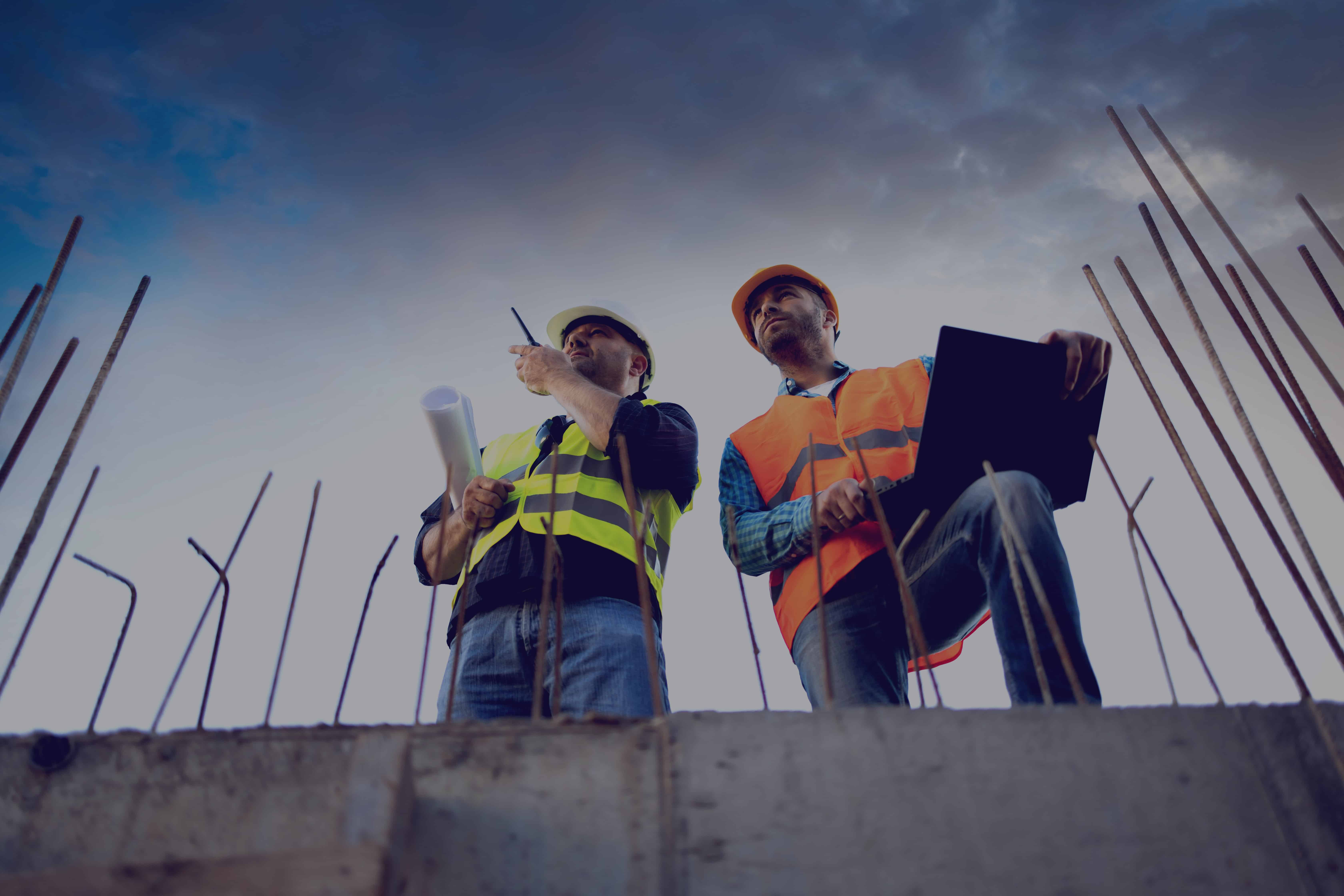 Men in hardhat and yellow and orange jacket posing on building site. stock photo Las Vegas plumbing contractor on commercial job site